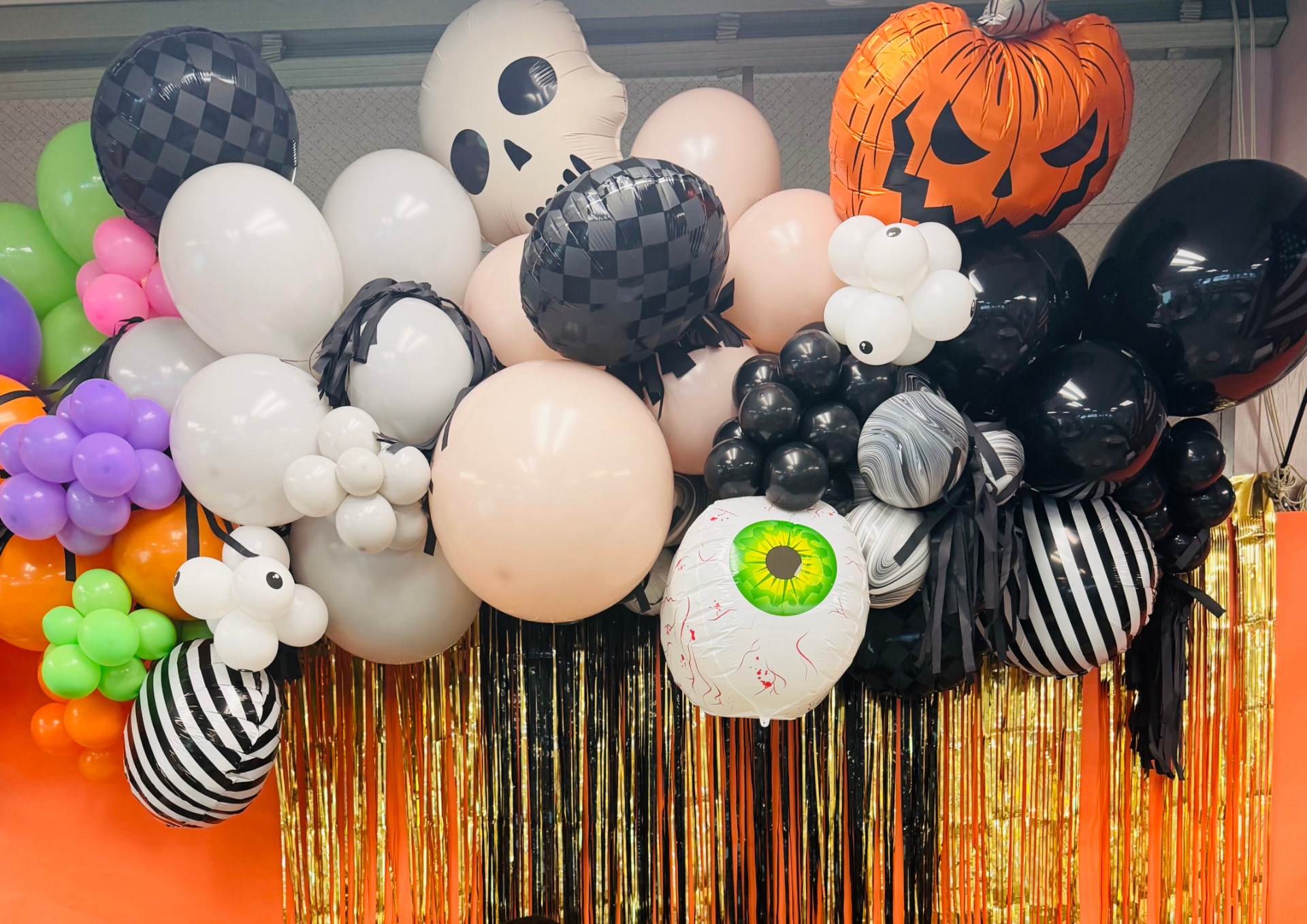 Halloween balloon garland with ghost, pumpkin, eyeball and checkered foil balloons
