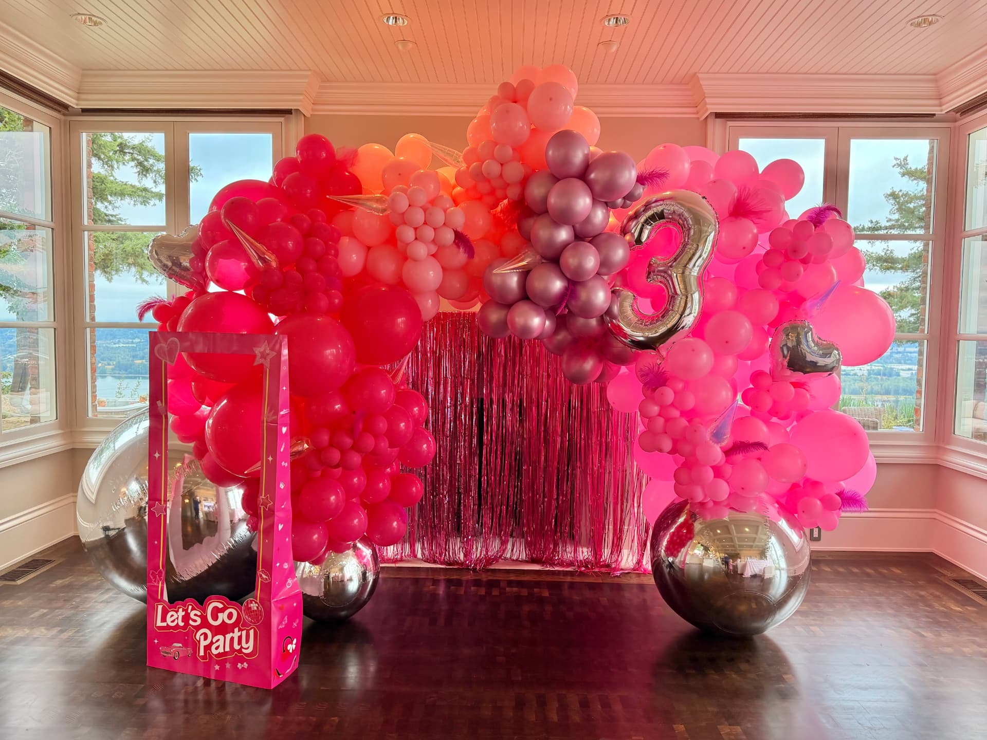 Bright pink Barbie-themed balloon arch with silver number three foil balloon